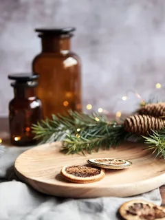 Decorazione natalizia con pigne e bicchieri ambra su tavola festiva