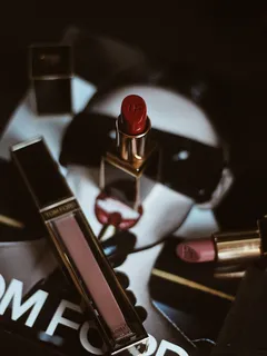 Rossetto rosso vicino a un altro rossetto rosso su sfondo chiaro