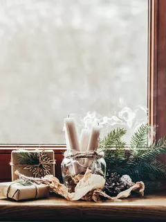 Decorazione natalizia con barattolo di vetro e candele sul davanzale