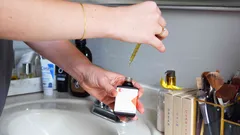 Persona che applica un test di glicemia con striscia sul dito in bagno