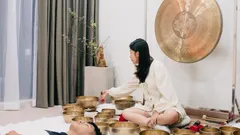 Donna che pratica terapia con ciotole tibetane in ambiente rilassante